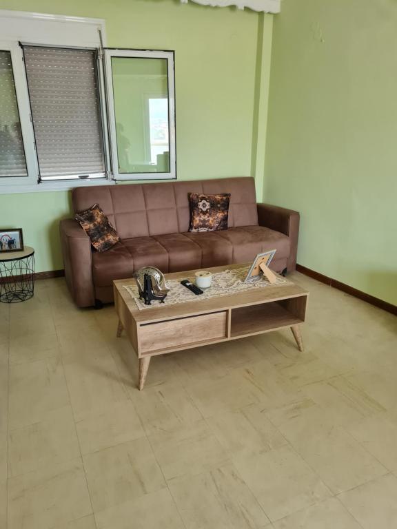 un soggiorno con divano marrone e tavolino da caffè di Center City Apt a Chio (Chios)