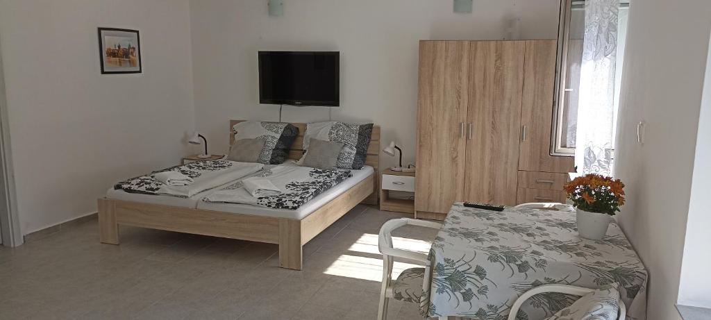 1 dormitorio con cama, mesa y TV en Apartmán GUTINO, en Česká Třebová