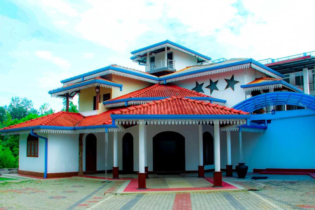 biały budynek z czerwonym dachem w obiekcie Relax Guest House w mieście Batapola