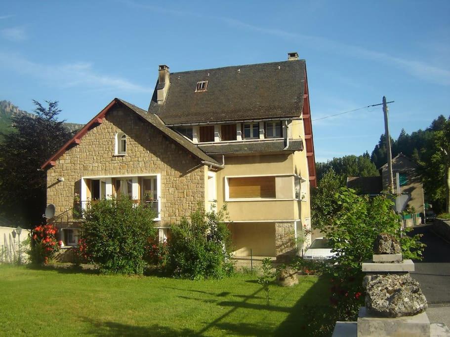 uma casa num quintal com um relvado verde em Au Bon vivre chez gégé 13 quartier de la Bessède em Florac