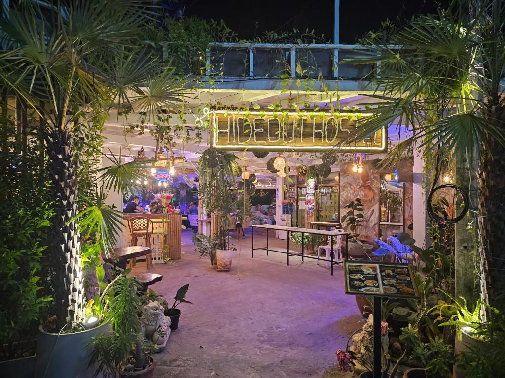 un restaurante con un montón de plantas y luces en Hideout Hostel en Haad Rin