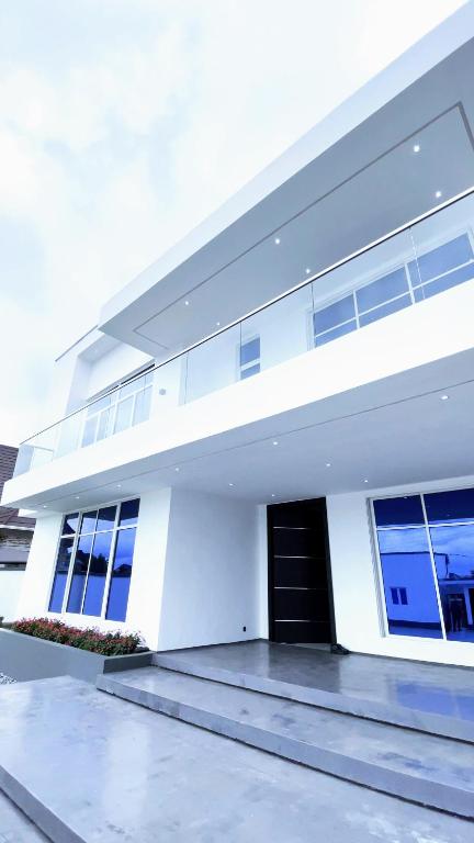 een groot wit gebouw met een zwarte deur bij Contemporary 4-Bedroom Villa with VR Room and Starlink Internet - Ifemide Estates in Akure