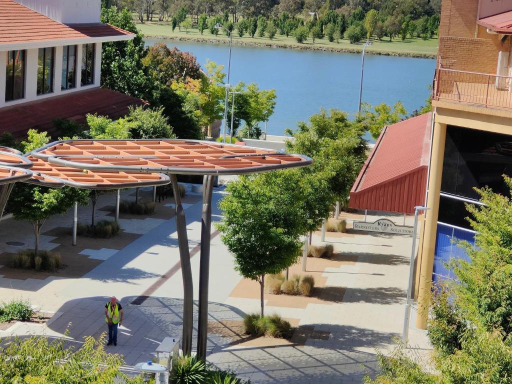 an overhead view of a patio with umbrellas and a lake at Tuggeranong Short Stay #07C - Sleeps 6 in Canberra