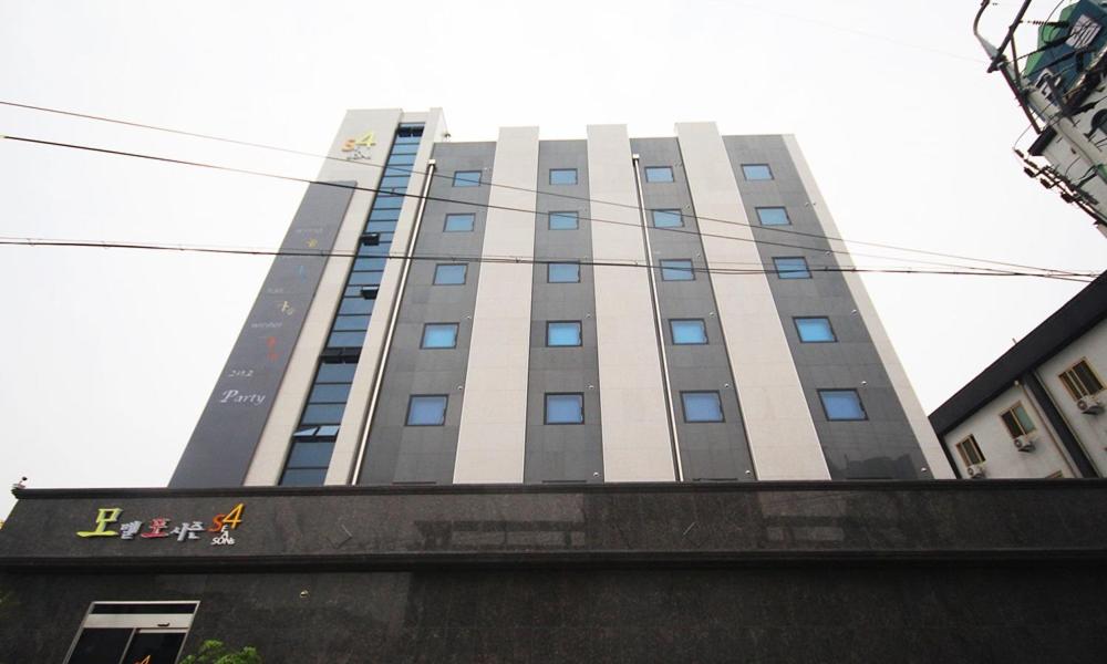 um edifício alto com um sinal em frente em Iksan 4 Seasons Hotel em Iksan