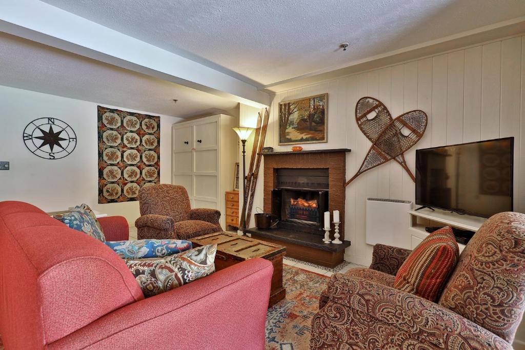 a living room with couches and a tv and a fireplace at Mountain Green Condo 3A10 condo in Killington