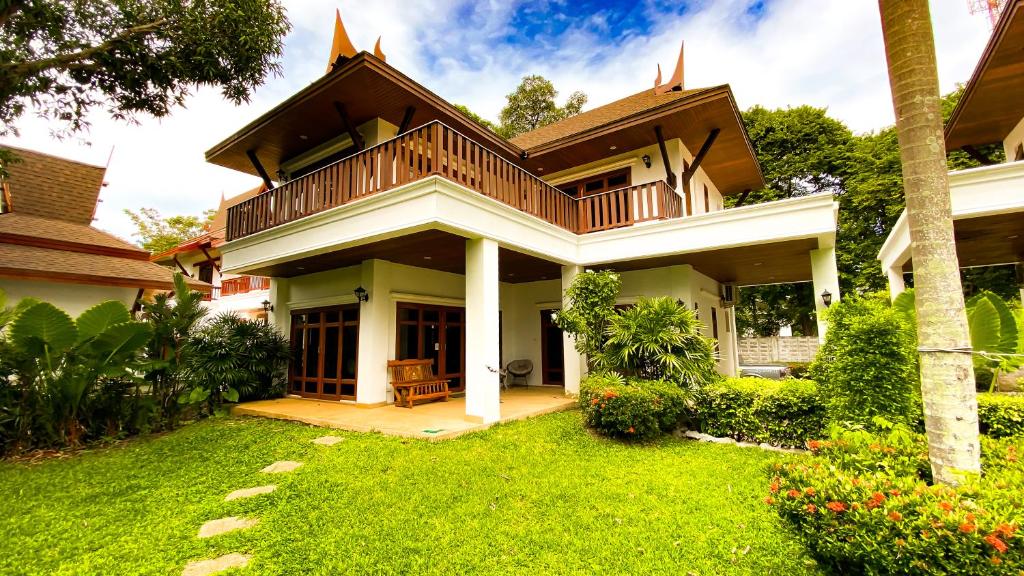 Una casa con un césped verde delante de ella. en Tropical garden, en Phuket