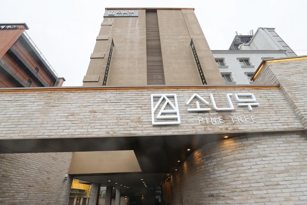 a building with a sign on the front of a store at Chuncheon Pine Tree Hotel in Chuncheon