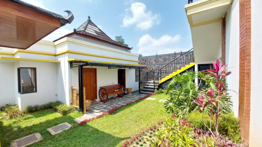 uma casa com um jardim e uma escada em Pool Villa Saung Suluh em Purwokerto