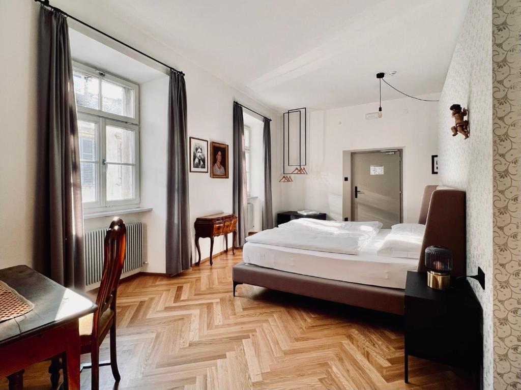 um quarto com uma cama, uma secretária e uma mesa em Haus Noldin - historische Herberge - dimora storica em Salorno