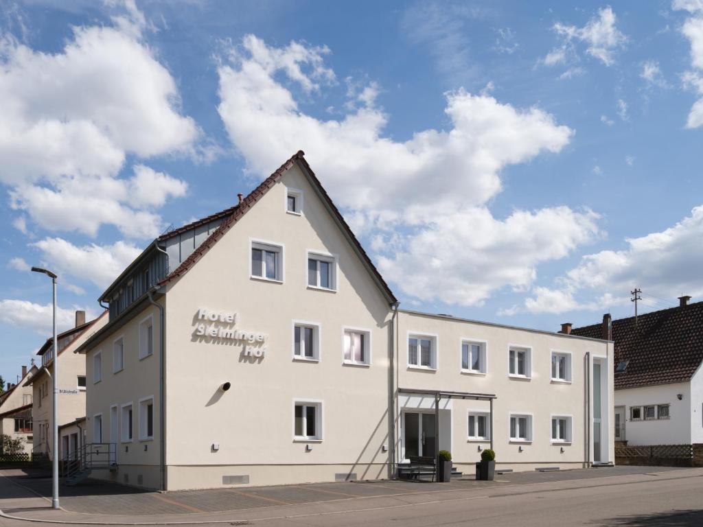 ein weißes Gebäude mit einem Schild an der Seite in der Unterkunft Hotel Sielminger Hof in Filderstadt