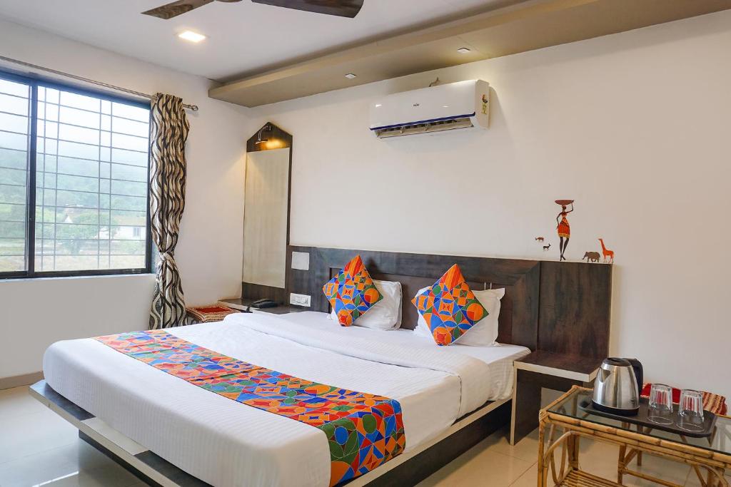 ein Schlafzimmer mit einem großen Bett und einem Fenster in der Unterkunft FabHotel Prime Meera Vatika in Mahabaleshwar
