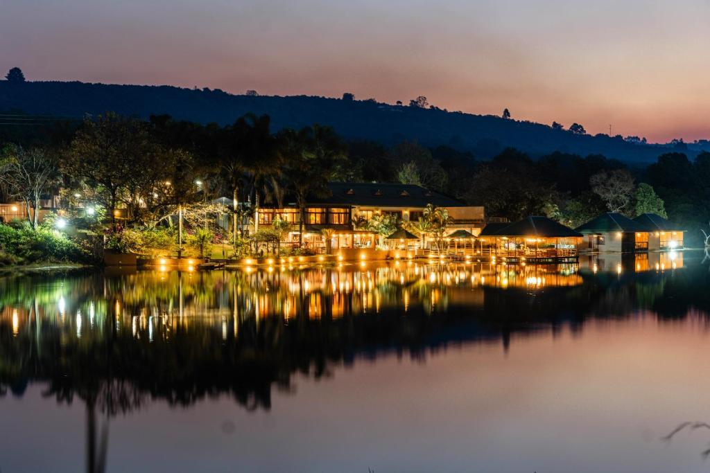 - une vue sur un complexe sur l'eau la nuit dans l'établissement Bambuu Lakeside Lodge, à Hazyview