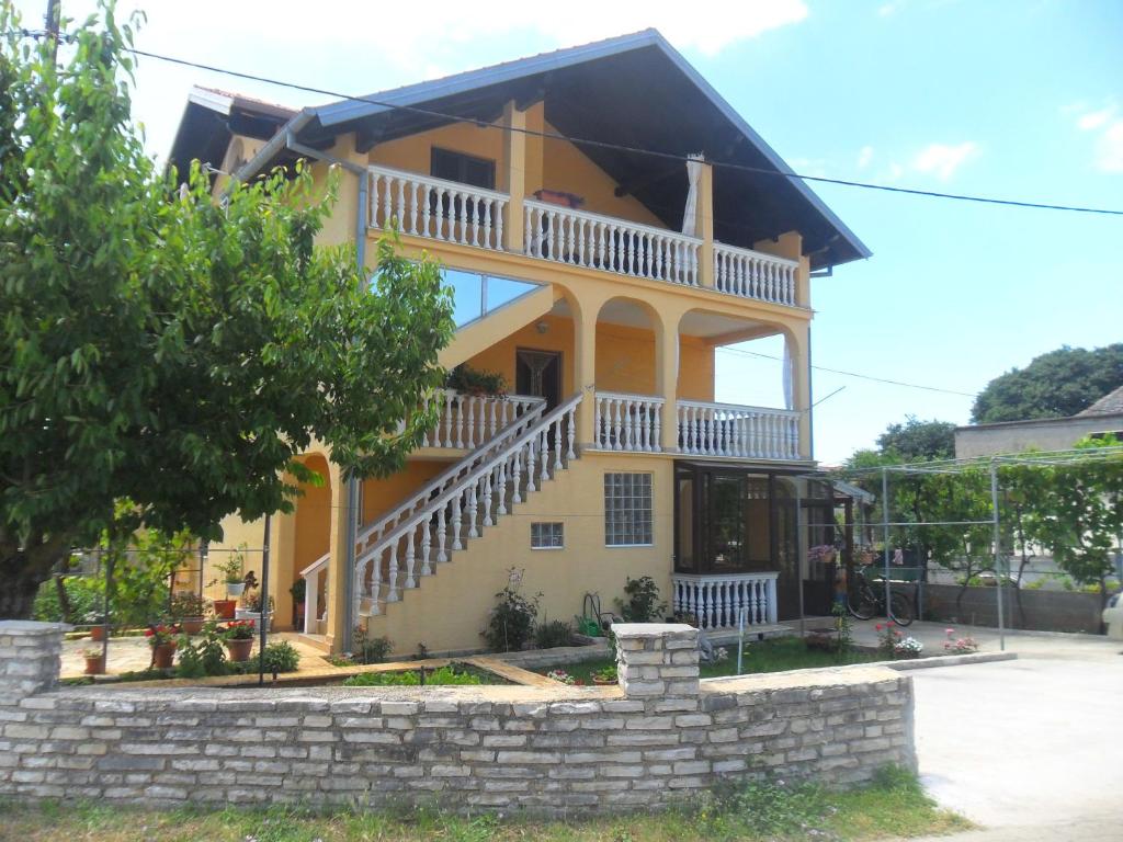 a large yellow house with a staircase in front of it at Apartments Stana in Sukošan