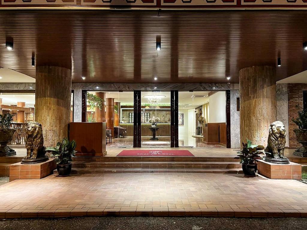 a lobby with two statues in the center of a building at The Borneo Hotel in Kuching