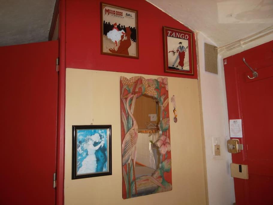 une chambre avec deux photos sur le mur et un miroir dans l'établissement Petit Studio climatisé Lamalou - IMPORTANT lire les détails sous le poste VOTRE HOTE avec photo, à Lamalou-les-Bains