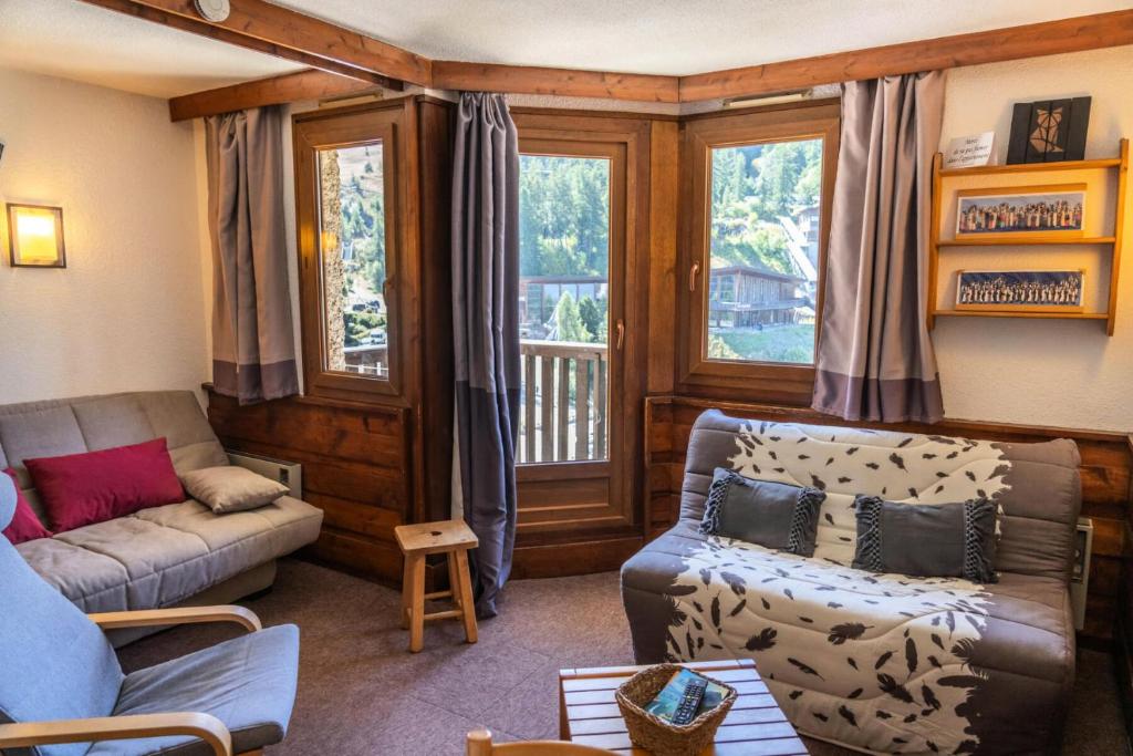 un salon avec un canapé et une chaise dans l'établissement Résidence Le Belvedere - Studio coin montagne au coeur des Orres 1650 MAE-6124, aux Orres