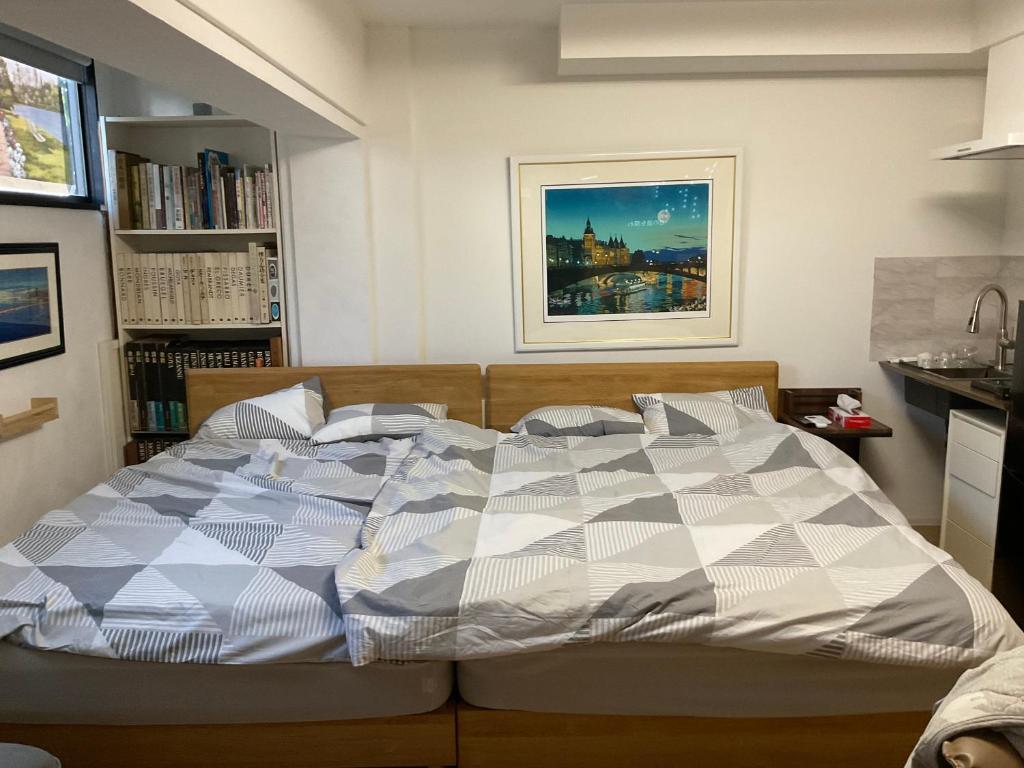 a bedroom with a bed with a blue and white comforter at Gallery Compass- Art Apartments Osaka with Breakfast Free Parking in Osaka