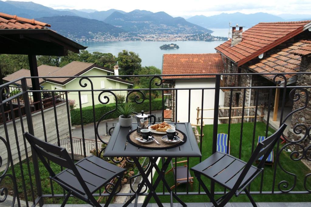 een tafel en stoelen op een balkon met uitzicht op het water bij Cà di Cambret with lake View in Stresa