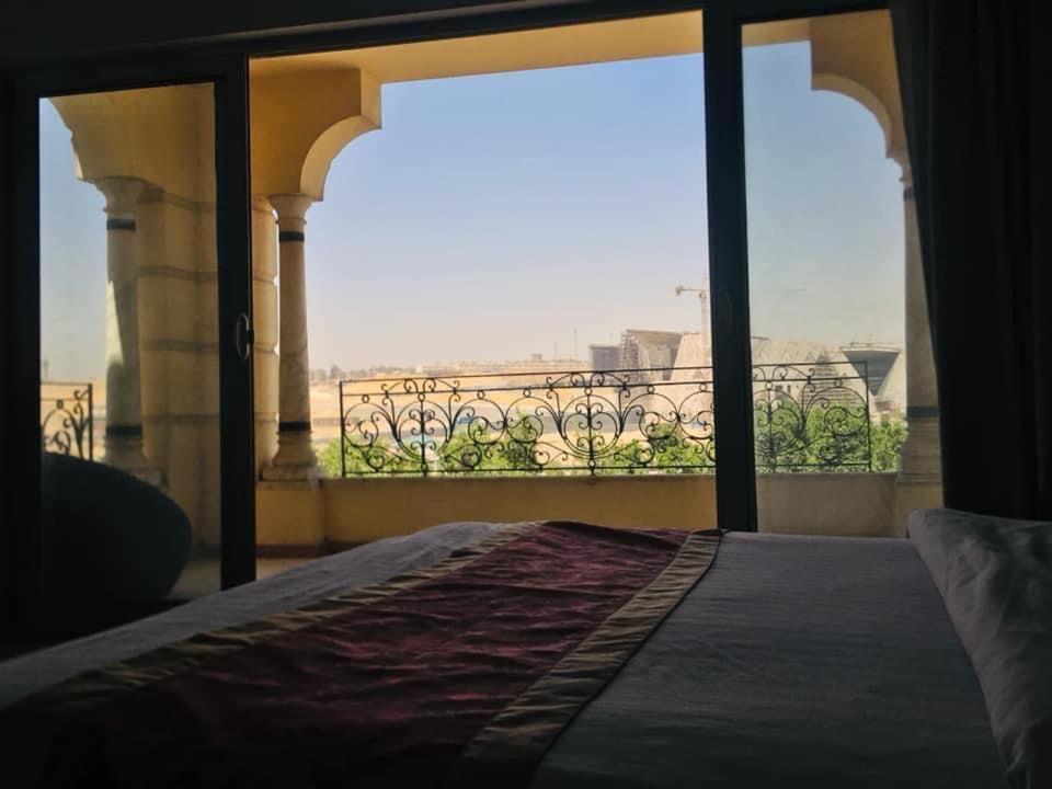 um quarto com uma cama e uma grande janela em Museum view no Cairo