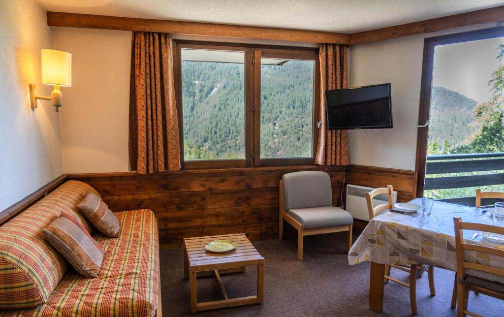 un salon avec un canapé, une table et une télévision dans l'établissement Résidence Le Belvedere - Appartement 2 pièces au coeur des Orres 1650 MAE-6254, aux Orres