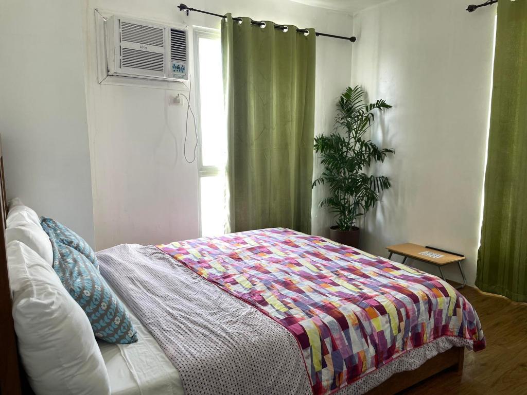 a bedroom with a bed and a window with a plant at *NEW* 2-Bedroom PENTHOUSE Condo Unit Centrio Tower(beside Ayala Centrio Mall) Downtown CDOC in Cagayan de Oro