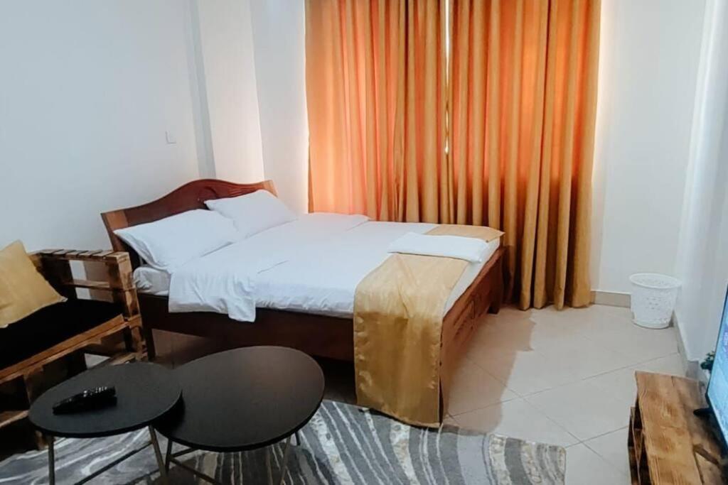 a bedroom with a bed and a table and chairs at Premier Stays Ruiru in Ruiru