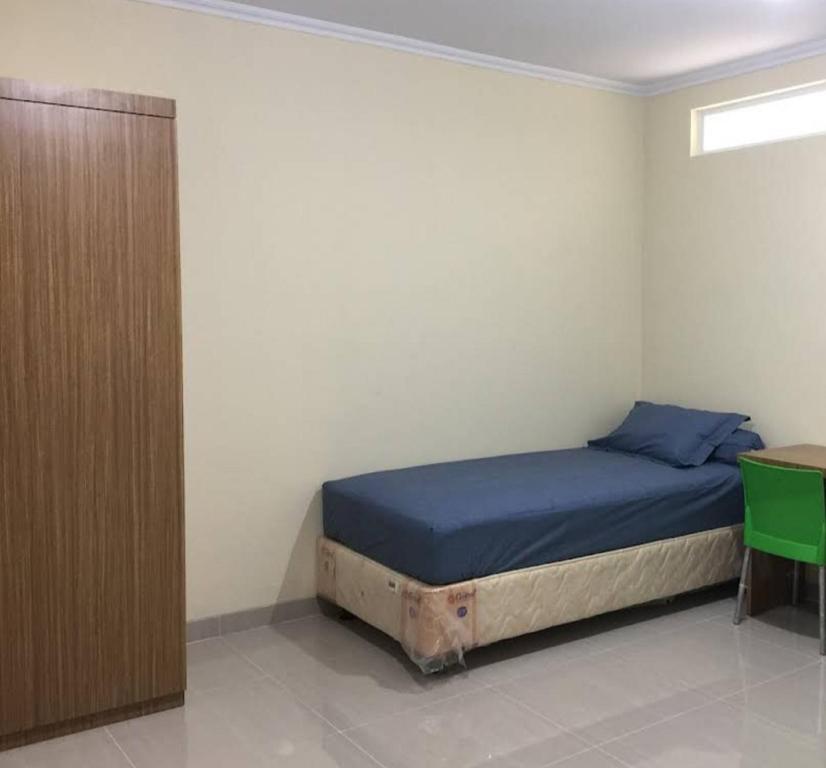 um quarto com uma cama e um armário de madeira em OYO Life 92781 Kost Parung Serab Syariah em Tangerang