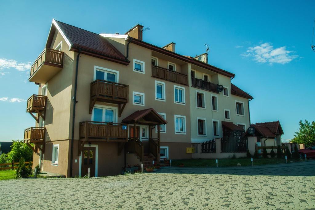 ein großes Gebäude mit Balkon auf der Seite in der Unterkunft Mazurski Zakątek-Apartamenty in Mikołajki