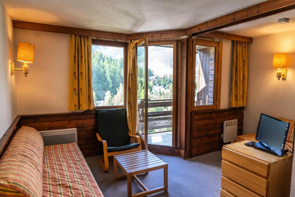 une chambre avec un lit, une chaise et une fenêtre dans l'établissement Résidence Le Belvedere - Studio coin nuit au coeur des Orres 1650 MAE-6354, aux Orres