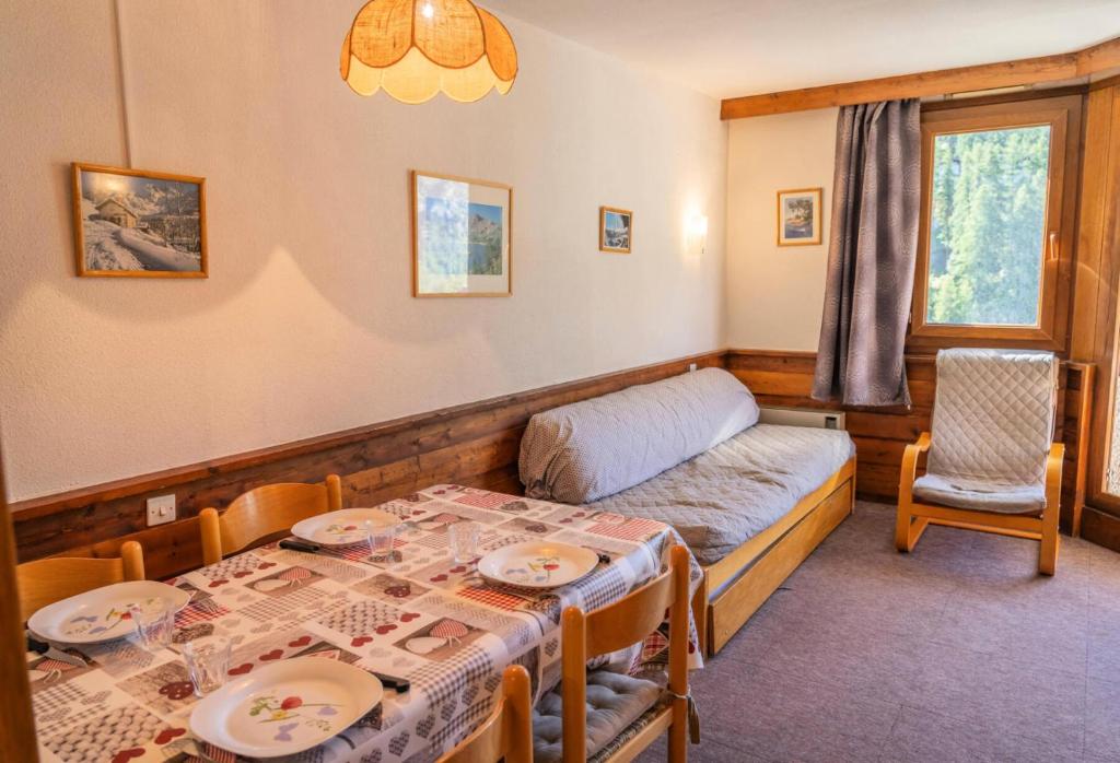 Cette petite chambre comprend une table et un lit. dans l'établissement Résidence Le Belvedere - Studio coin montagne au coeur des Orres 1650 MAE-6384, aux Orres