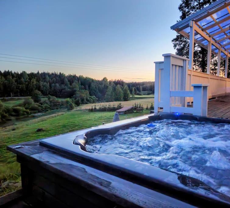 uma grande banheira de hidromassagem sentada num quintal em Luksusta mökkeilyyn Villa Sörkkä em Metsämaa