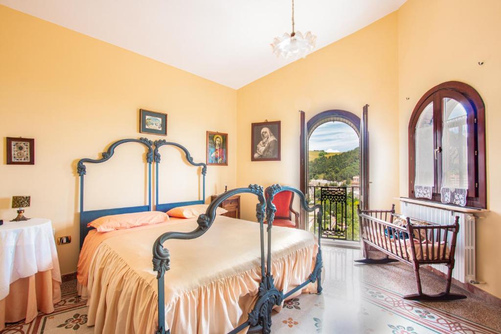 1 dormitorio con cama, mesa y ventanas en Casa Bizzarro, en Deliceto
