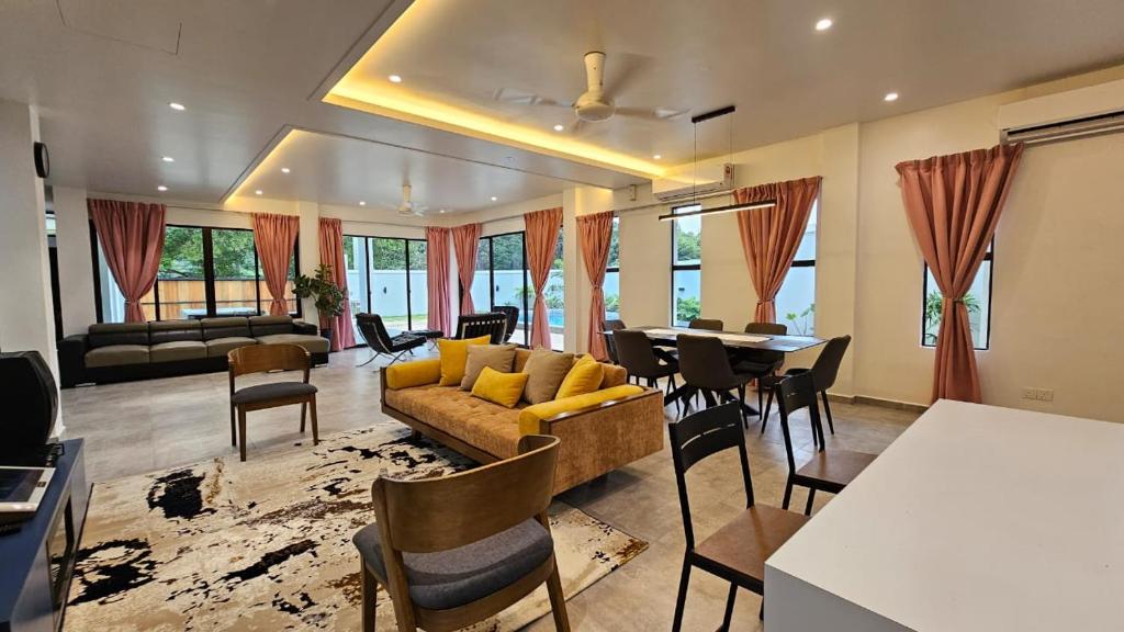 sala de estar con sofá, mesa y sillas en Rumah Amaan en Kuah
