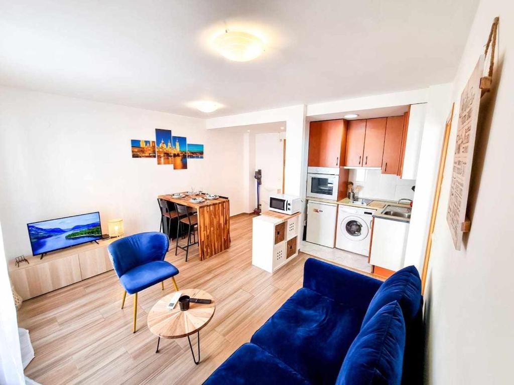 Il comprend un salon avec un canapé bleu et une cuisine. dans l'établissement Aguadores del Pilar ComoTuCasa, à Saragosse