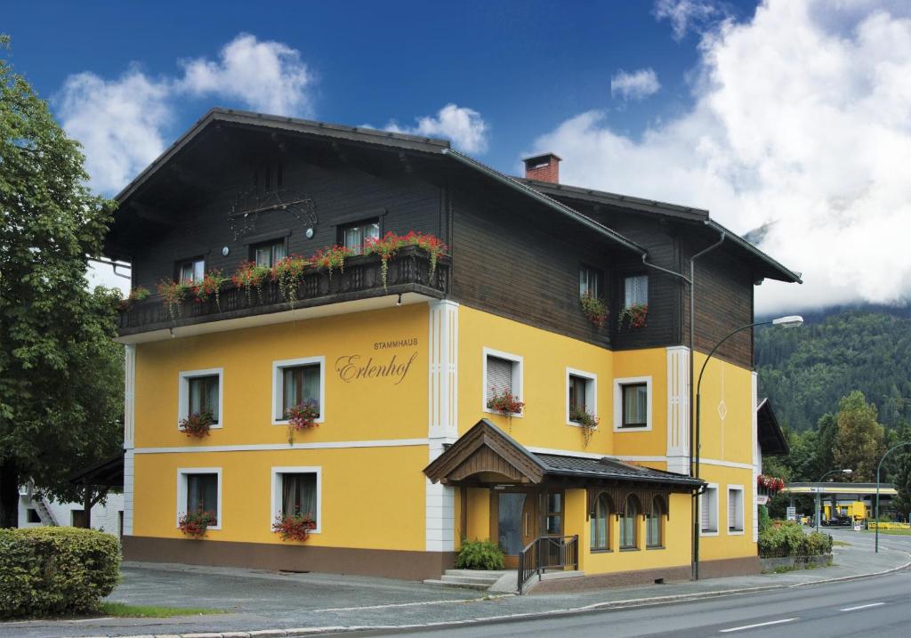 ein gelbes Gebäude mit schwarzem Dach in der Unterkunft Erlenhof B&B in Kötschach