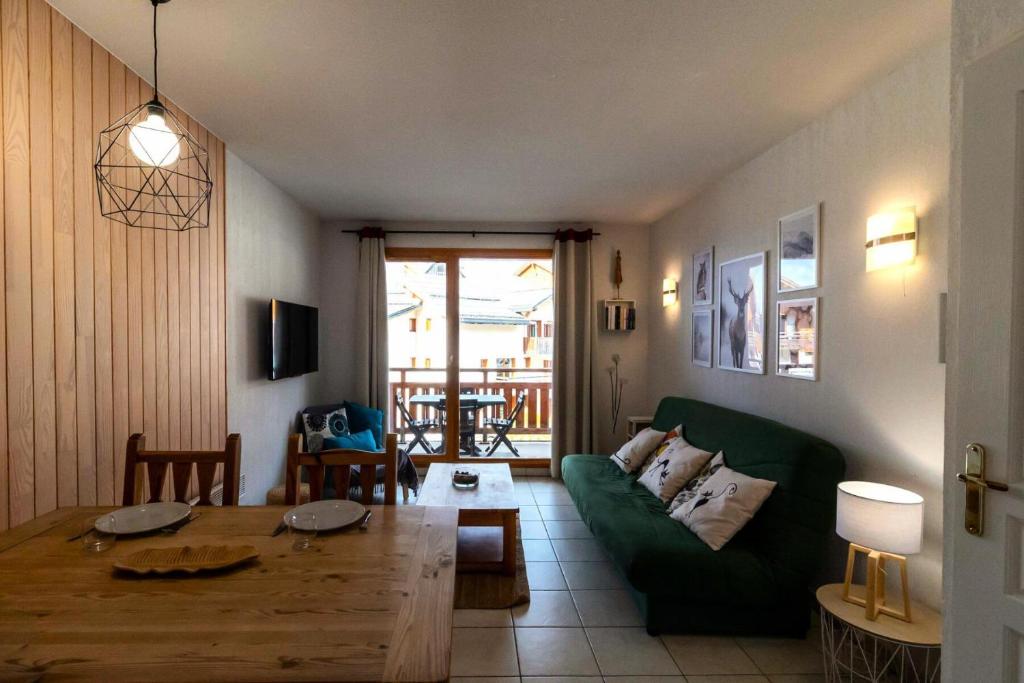 un salon avec un canapé vert et une table dans l'établissement Résidence Le Balcon Des Airelles - Agréable appartement proche des pistes MAE-6504, aux Orres