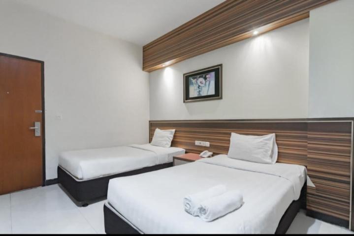 Hotel Setrasari Bandung في باندونغ: غرفه فندقيه سريرين