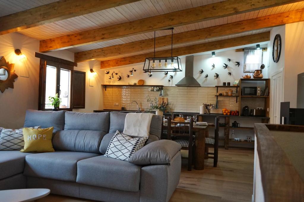 sala de estar con sofá y cocina en La Casita de los Pájaros en San Martín de Valdeiglesias
