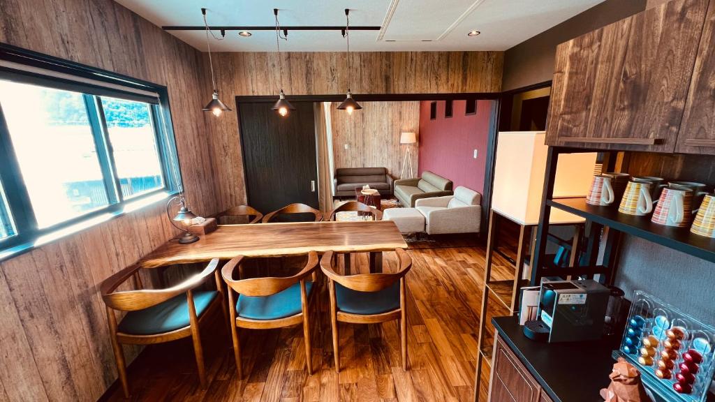 una sala da pranzo con tavolo e sedie in legno di 女性専用貸切の宿 月舟庵 Private female-only accommodation Tsukifunean ad Asuka