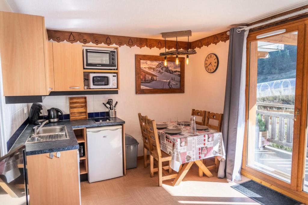 Il comprend une cuisine et une salle à manger avec une table. dans l'établissement Résidence Le Parc Des Airelles - Studio 4 personnes avec vue sur les pistes MAE-6684, aux Orres