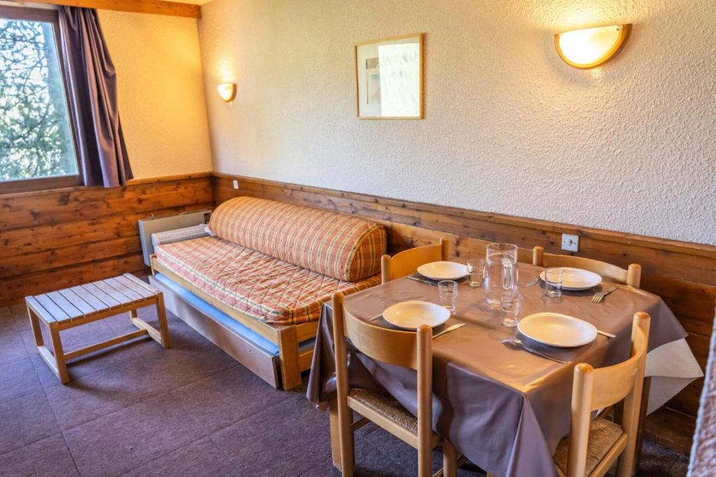 une salle à manger avec une table et un canapé dans l'établissement Résidence Le Belvedere - Studio coin nuit au coeur des Orres 1650 MAE-6724, aux Orres