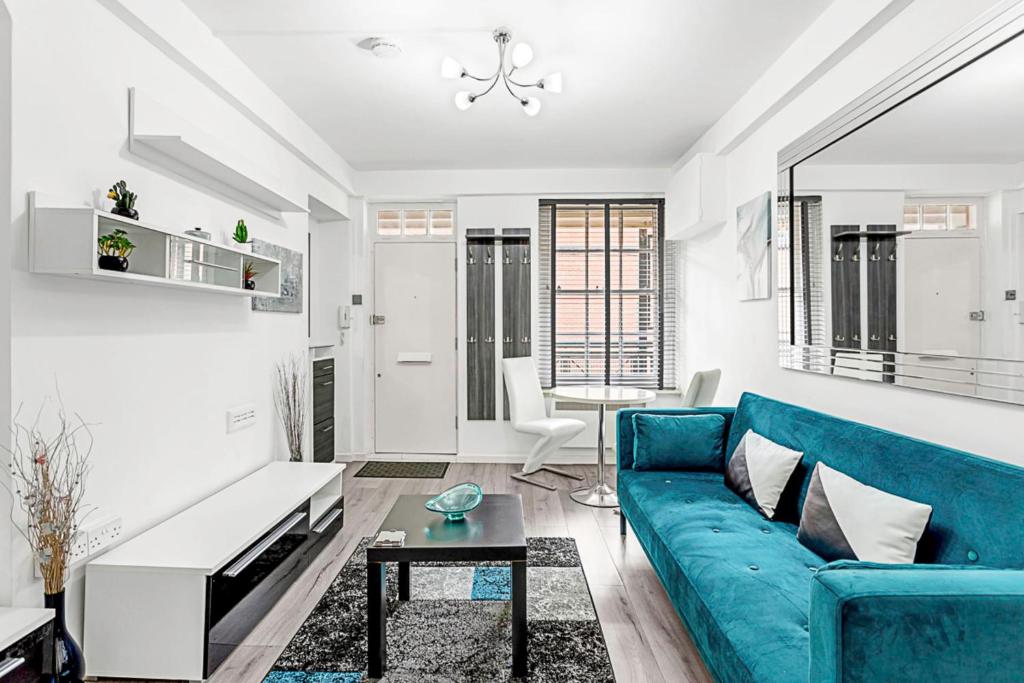 a living room with a blue couch and a table at Cozy Covent Garden Gem in London