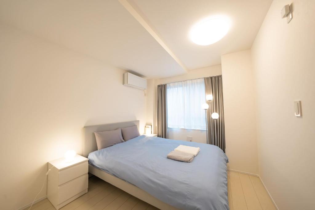 a small bedroom with a bed and a window at FL Residence Todai II in Tokyo