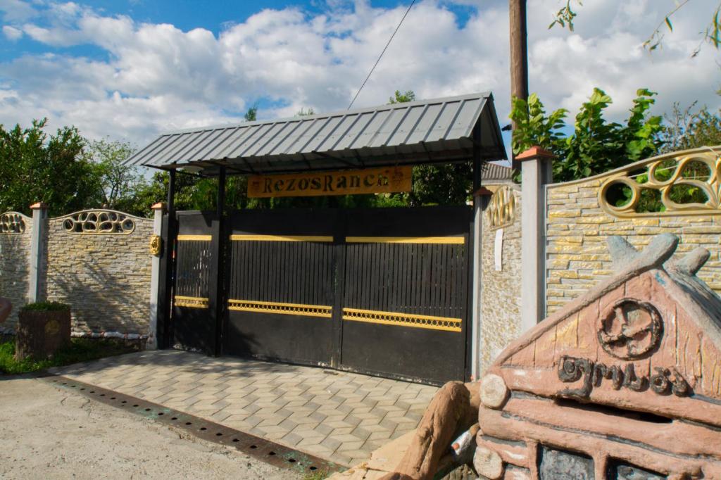 een poort naar een huis met een bord erop bij Rezo's Ranch in Samtredia