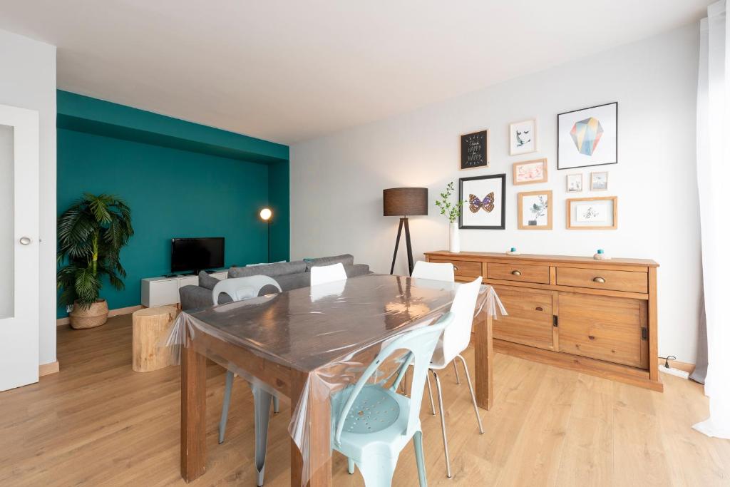 une salle à manger avec une table, des chaises et un canapé dans l'établissement Le St Honoré - 7ème étage avec vue sur la ville, à Toulouse