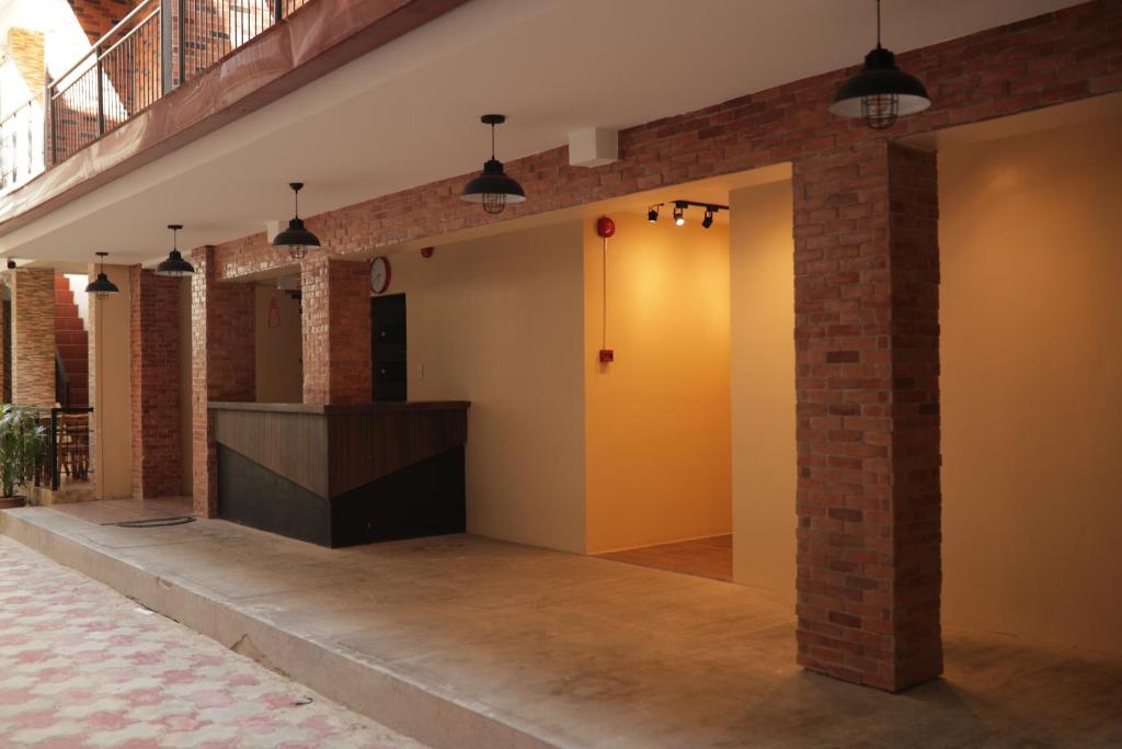 a lobby with a yellow door and a brick wall at Cerca Hotel in Boracay