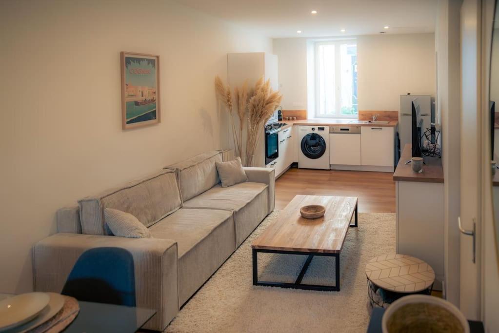 ein Wohnzimmer mit Sofa und Tisch in der Unterkunft SplendideT2 centre ville & terrasse extérieure in Cognac