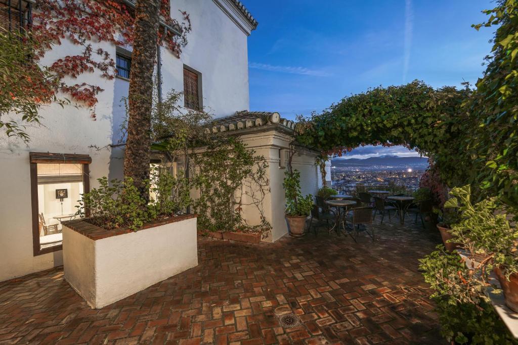 a patio with a table and chairs in a building at Carmen de la Alcubilla del Caracol in Granada
