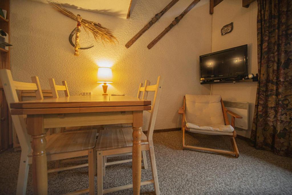 Zimmer mit einem Tisch, Stühlen und einem TV in der Unterkunft Résidence Le Pouzenc - Studio pour 6 Personnes 424 in Les Orres
