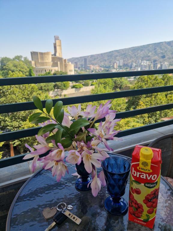uma mesa com um vaso azul com flores em Fantaflat Old Tbilisi Apartment em Tbilisi